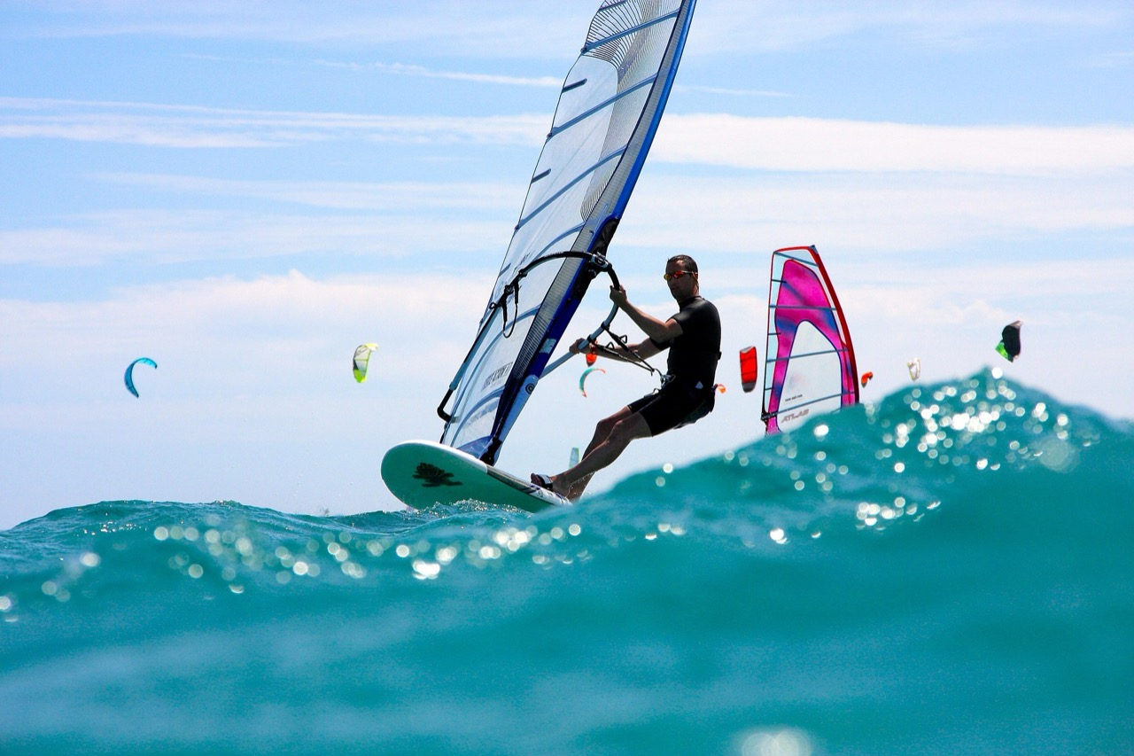 Windsurfing through waves at Koh Phangan — kites visible in the background