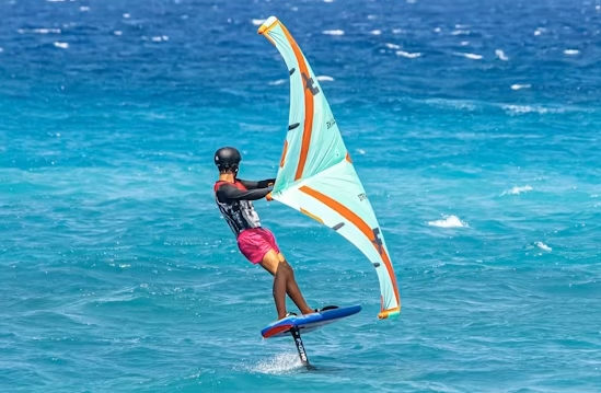 Wing foiling on Koh Phangan — rider on hydrofoil with inflatable wing, blue ocean